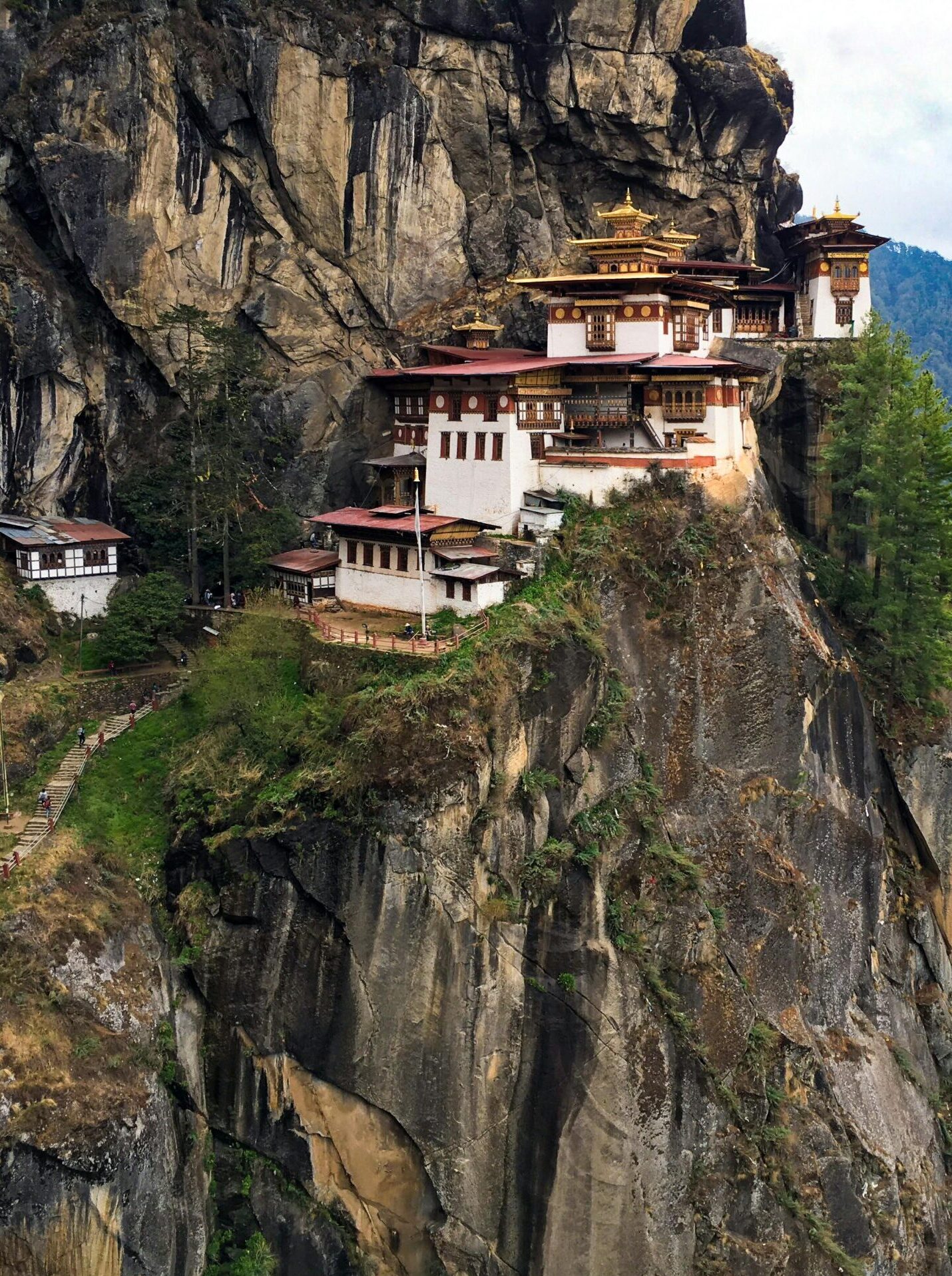 Cliffside monastery surrounded by lush green mountains