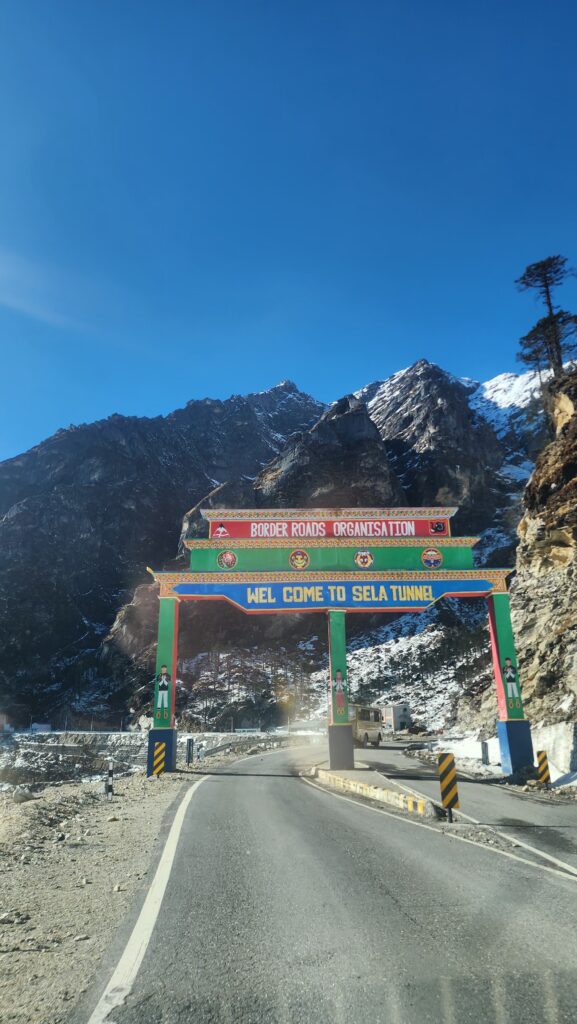 Welcome board at Sela Tunnel surrounded by snow-capped mountains, part of Sagamiles travel journeys